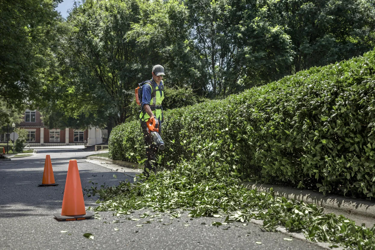 Landscape maintenance staff cutting leaves using Husqvarna 530iBX Blower