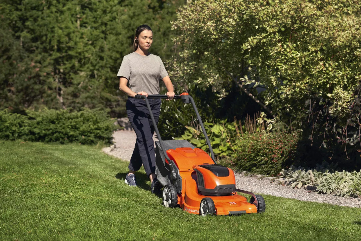 Woman using a Husqvarna LC247i Lawn Mower